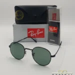 Lunettes de soleil Ray-Ban Round Metal RB3447 noires avec verres verts G-15, étui noir, boîte grise et livret de garantie chez Optical Gallery.