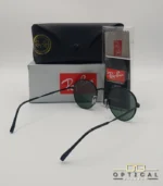 Lunettes de soleil Ray-Ban Round Metal RB3447 noires avec verres verts G-15, étui noir, boîte grise et livret de garantie chez Optical Gallery.