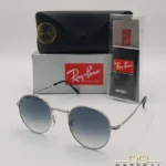 Lunettes de soleil Ray-Ban Julie RB3772 argentées avec verres dégradés bleus gris, étui noir, boîte grise et livret de garantie chez Optical Gallery.