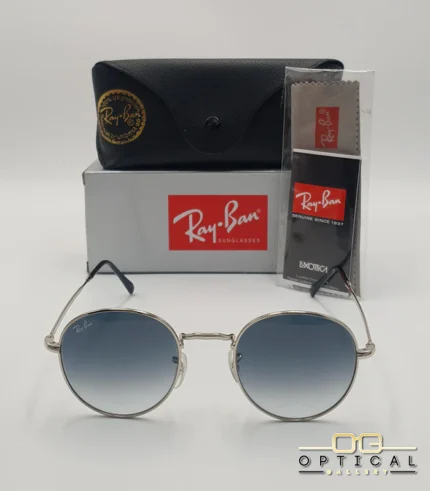 Lunettes de soleil Ray-Ban Julie RB3772 argentées avec verres dégradés bleus gris, étui noir, boîte grise et livret de garantie chez Optical Gallery.