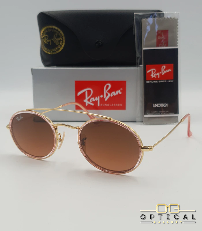 lunettes-de-soleil-ray-ban-round-double-bridge-rb3847n-or-rose-transparent-marron-degrade-optical-gallery Lunettes de soleil Ray-Ban Round Double Bridge RB3847N dorées avec cerclages en acétate rose transparent et verres dégradés marrons, étui noir, boîte grise et livret de garantie chez Optical Gallery.