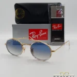 Lunettes de soleil Ray-Ban Round Double Bridge RB3847N dorées avec cerclages en acétate transparent et verres dégradés bleus gris, étui noir, boîte grise et livret de garantie chez Optical Gallery.