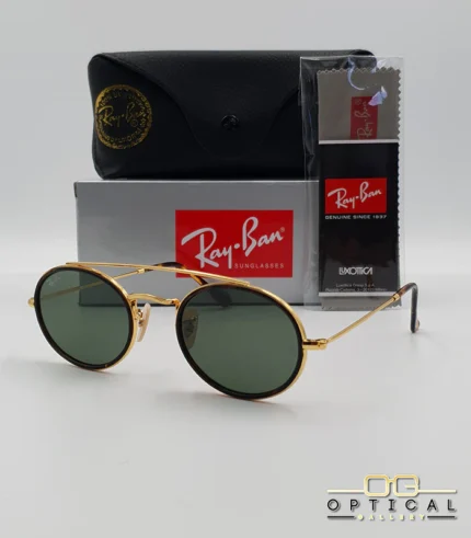 Lunettes de soleil Ray-Ban Round Double Bridge RB3847N dorées avec cerclages en acétate écaille de tortue et verres verts G-15, étui noir, boîte grise et livret de garantie chez Optical Gallery.