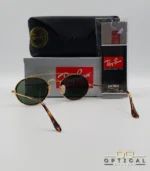 Lunettes de soleil Ray-Ban Round Double Bridge RB3847N dorées avec cerclages en acétate écaille de tortue et verres verts G-15, étui noir, boîte grise et livret de garantie chez Optical Gallery.