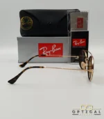 Lunettes de soleil Ray-Ban Round Double Bridge RB3847N dorées avec cerclages en acétate noir et verres marrons B-15, étui noir, boîte grise et livret de garantie chez Optical Gallery.