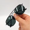 Lunettes de soleil Ray-Ban Jack Double Bridge noires tenues à la main avec monture géométrique en métal noir et verres verts G-15 chez Optical Gallery.