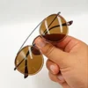 Lunettes de soleil Ray-Ban Jack Double Bridge noires tenues à la main avec monture géométrique en métal noir et verres verts G-15 chez Optical Gallery.