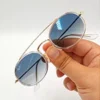 Lunettes de soleil Ray-Ban Jack Double Bridge noires tenues à la main avec monture géométrique en métal noir et verres verts G-15 chez Optical Gallery.