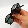 Lunettes de soleil Ray-Ban Jack Double Bridge noires tenues à la main avec monture géométrique en métal noir et verres verts G-15 chez Optical Gallery.