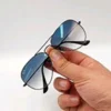 Lunettes de soleil Ray-Ban Jack Double Bridge noires tenues à la main avec monture géométrique en métal noir et verres verts G-15 chez Optical Gallery.